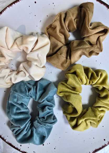 Set aus vier samtigen Scrunchies in Vanilla Cream, Toffee Glow, Golden Olive und Dusty Blue – luxuriöse Haaraccessoires mit edlem Glanz von Saltberry Lane.