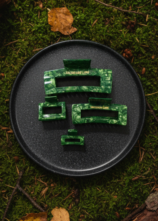 Moss Boss Haarspange von Saltberry Lane – moosgrüner Haarclip als Flatlay auf Waldboden mit Blättern und Rinde, naturverbundenes Herbst-Styling